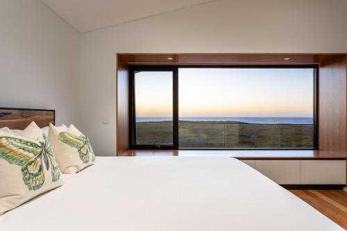 a bedroom with a large bed and a large window at The Duke I Private Properties in Gnarabup