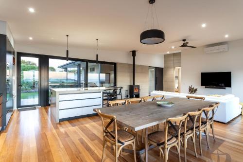 a kitchen and dining room with a wooden table and chairs at The Duke I Private Properties in Gnarabup