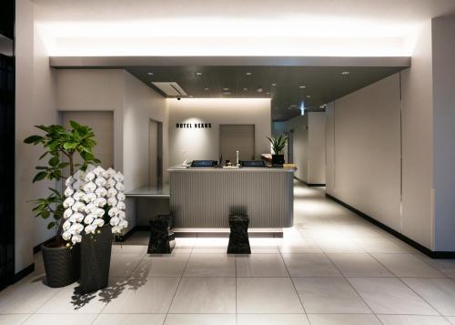 un vestíbulo de oficina con recepción y plantas en HOTEL NEXUS Hakata Sanno en Fukuoka