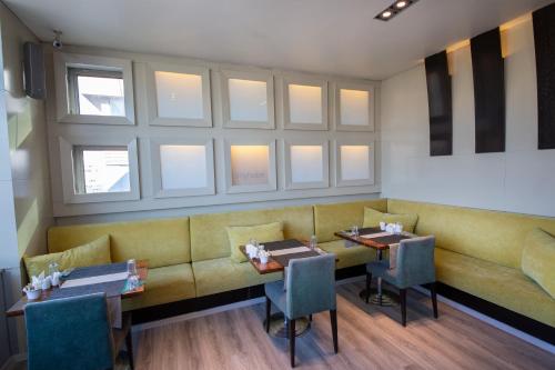 a restaurant with a couch and tables and windows at MY Hotel in Izmir