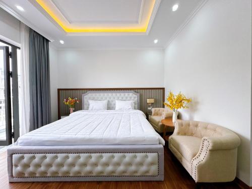 下龍灣的住宿－Phượng Hoàng villa，一间卧室配有一张大床和一把椅子