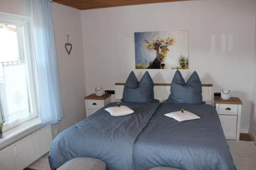 a bedroom with a large blue bed with blue pillows at Haus Sonnenhang Wohnung 1 in Stiefenhofen