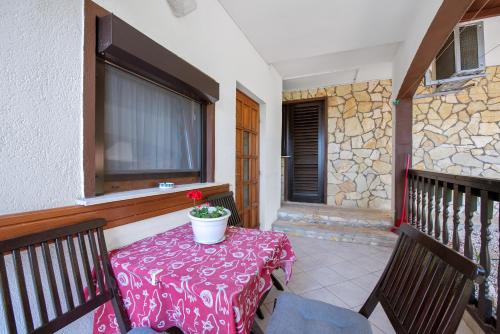una mesa con una maceta en el balcón en Pansion Adria Haus, en Posedarje