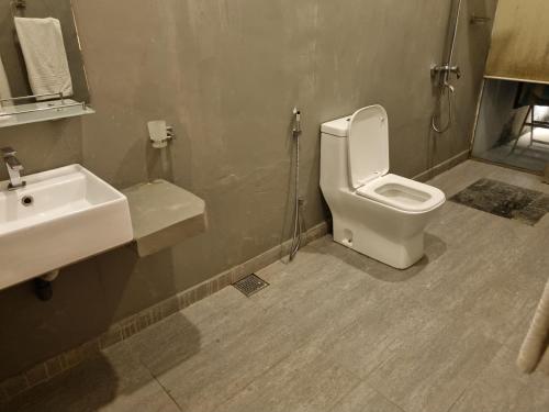 a bathroom with a white toilet and a sink at River Front Villa in Wadduwa