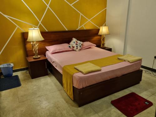 a bedroom with a bed with pink and yellow walls at River Front Villa in Wadduwa