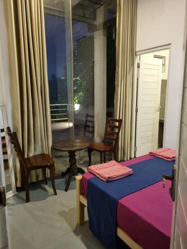 a bedroom with two beds and a table and chairs at River Front Villa in Wadduwa
