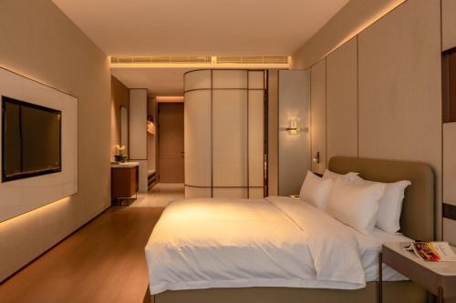 ZengchengにあるGuus Hotelのベッドルーム(白いベッド1台、テレビ付)