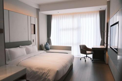 a hotel room with a large bed and a desk at Guus Hotel in Zengcheng
