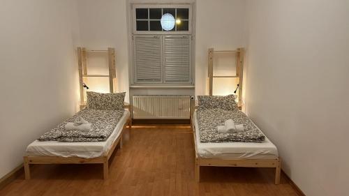 two beds in a room with a window at Mapi Apartment in Dresden