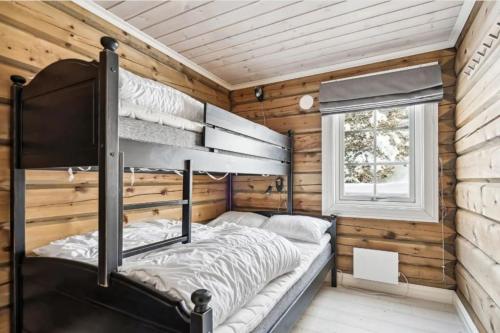 a bedroom with a bunk bed in a log cabin at BjorliKos in Bjorli