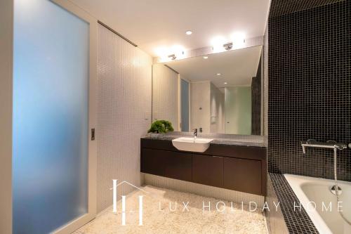 a bathroom with a sink and a tub and a mirror at LUX The Elegant DIFC Suite 2 in Dubai