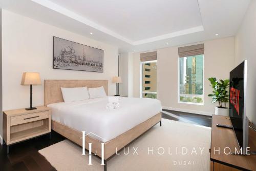 杜拜的住宿－LUX The Elegant DIFC Suite 2，卧室配有一张白色大床和电视。