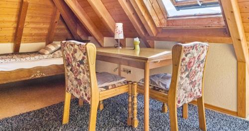 a table and chairs in a room with bunk beds at Ferienwohnung Pfisterhof in Kirchzarten
