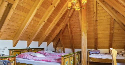 Duas camas num quarto com tectos em madeira em Ferienwohnung Pfisterhof em Kirchzarten