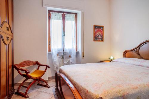 1 dormitorio con 1 cama, 1 silla y 1 ventana en Casa marina Ampio - Castiglione, en Castiglione della Pescaia