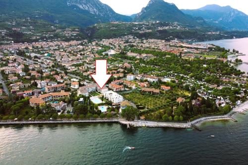 GARDA BLUE HOME on the lake - pool, solarium and garage في توسكولانو ماديرنو: جزيره في الماء بسهم ابيض