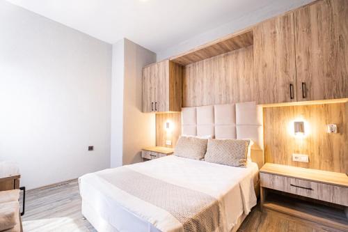 a bedroom with a white bed and wooden cabinets at Hotel Centro Bodrum in Bodrum City