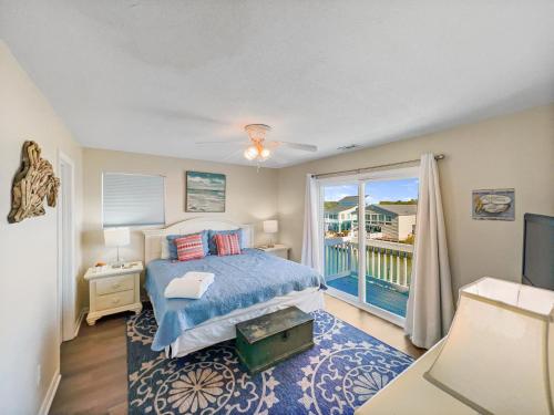 ein Schlafzimmer mit einem Bett und einem Balkon in der Unterkunft Lazy Days In Cherry Grove! in Myrtle Beach