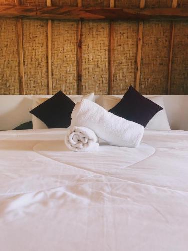 a white towel sitting on top of a bed at Sakti OceanView Nusa Penida in Nusa Penida