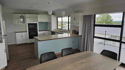 a kitchen with a table and chairs and a large window at Grandpa’s Place in Te Aroha