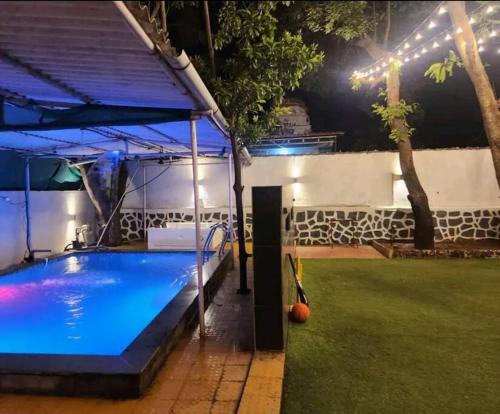 a pool in a backyard at night with lights at BnBBuddy- Great Escape@Karjat, Maharashtra in Karjat