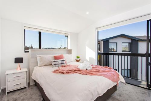 a bedroom with a bed and a large window at Penthouse Apartment Scenic Views-Spacious 2br in Christchurch