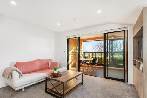 a living room with a couch and a table at Penthouse Apartment Scenic Views-Spacious 2br in Christchurch