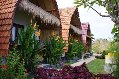 a row of cottages with flowers and plants at Sakti OceanView Nusa Penida in Nusa Penida