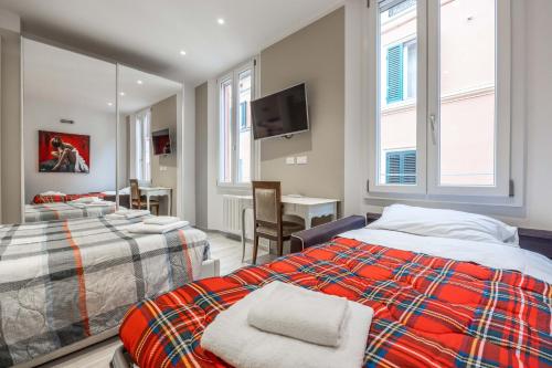 una camera con 2 letti, una TV e un tavolo di De'Giudei, Bologna by Short Holidays a Bologna
