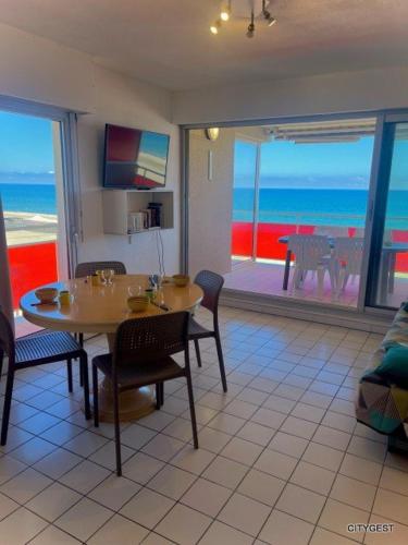 une salle à manger avec une table et une vue sur l'océan dans l'établissement Appartement T2 vue Mer, moderne, clim 3 etoiles Parking 4PLMER53, à Canet