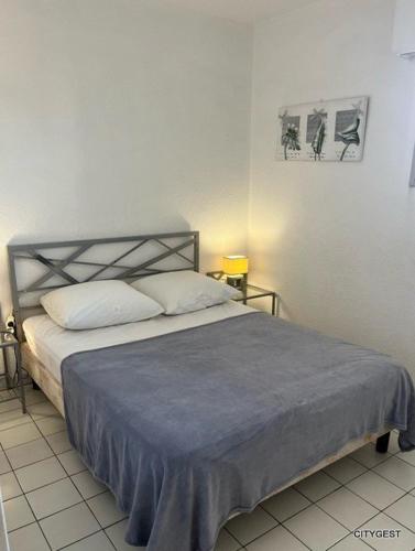 - une chambre avec un lit doté d'une couverture bleue dans l'établissement Appartement T2 vue Mer, moderne, clim 3 etoiles Parking 4PLMER53, à Canet