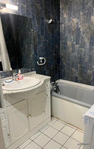 une salle de bain avec un lavabo et une baignoire dans l'établissement Appartement T2 vue Mer, moderne, clim 3 etoiles Parking 4PLMER53, à Canet