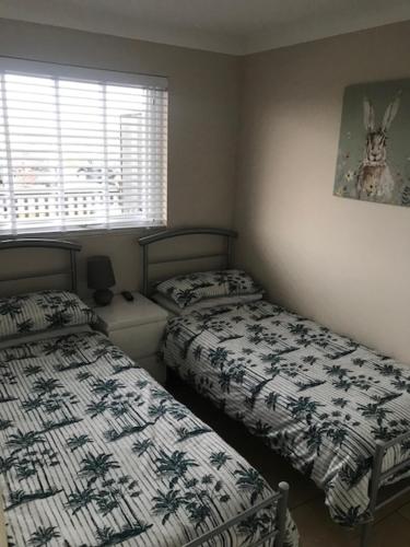 1 dormitorio con 2 camas y ventana en Seaview Cottage, en Bacton