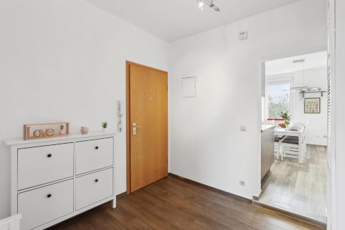 a living room with white walls and a wooden door at Stylish & Relaxing Penthouse ~ Workspace ~ Parking in Gelsenkirchen