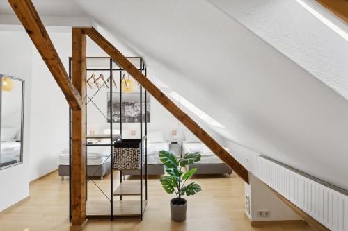 un escalier dans une maison avec une plante en pot dans l'établissement Stylish & Relaxing Penthouse ~ Workspace ~ Parking, à Gelsenkirchen