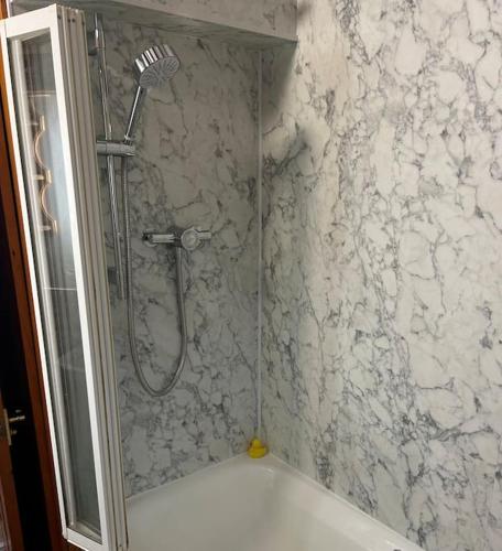 a shower in a bathroom with a marble wall at Twattleton Cottage Kilburn Yorkshire - Beautiful views in York