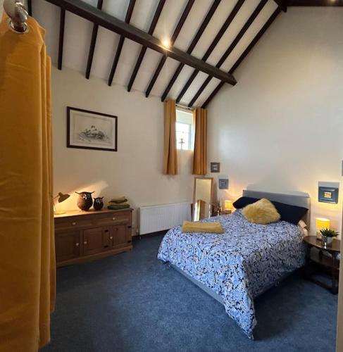 a bedroom with a bed and a wooden ceiling at Twattleton Cottage Kilburn Yorkshire - Beautiful views in York