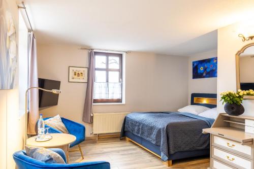 a small bedroom with a bed and a table at Schlossberg-Hotel Garni in Wernigerode