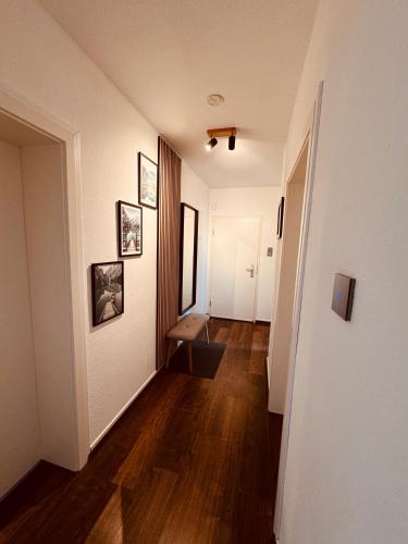 a hallway with white walls and a wooden floor at Moderne Ferienwohnung Iserlohn 2 in Iserlohn