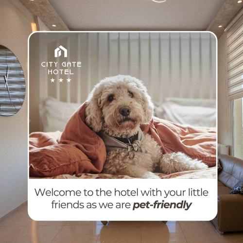 a dog sitting on a bed with a sign that says welcome to the hotel with at City Gate Hotel Airport Thessaloniki in Thessaloniki