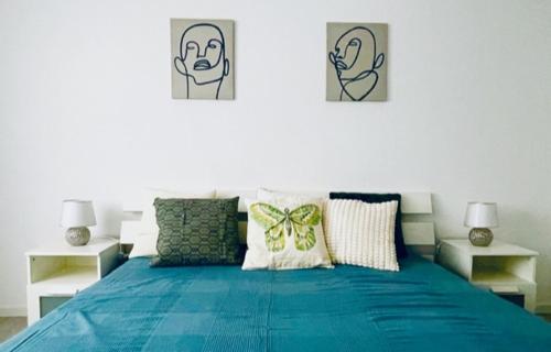 a bedroom with a blue bed with two pictures on the wall at Allegra Appartements in Nohfelden