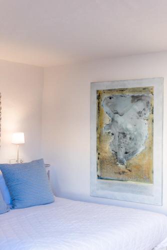 a bedroom with a bed and a painting on the wall at ES CUCONS RURAL HOTEL in San Antonio