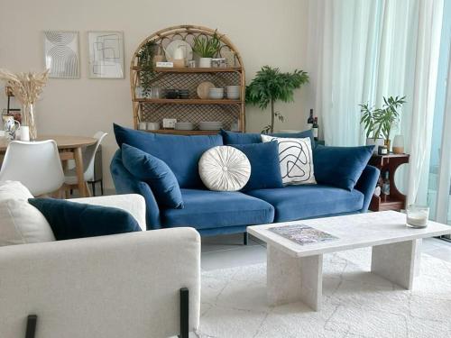un soggiorno con divano blu e tavolo di Gindi Tower Apartments TLV a Tel Aviv