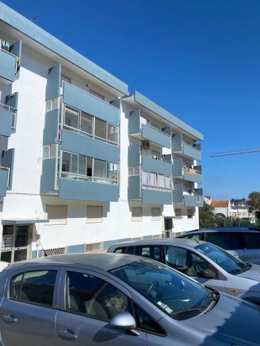 two cars parked in a parking lot in front of a building at Casa Alves in Palmela