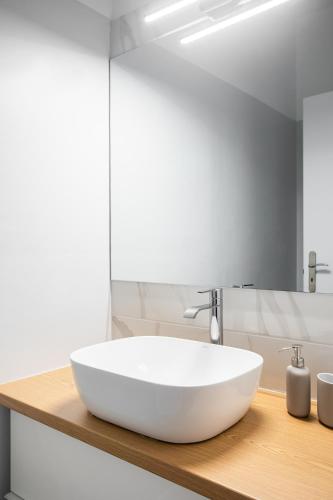a bathroom with a white sink and a mirror at The Gate by Zoia Living in Athens