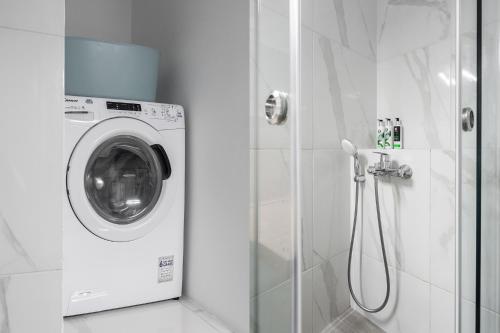 a washing machine in a bathroom with a shower at The Gate by Zoia Living in Athens