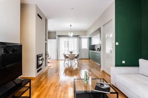 a living room with a white couch and a green wall at The Gate by Zoia Living in Athens