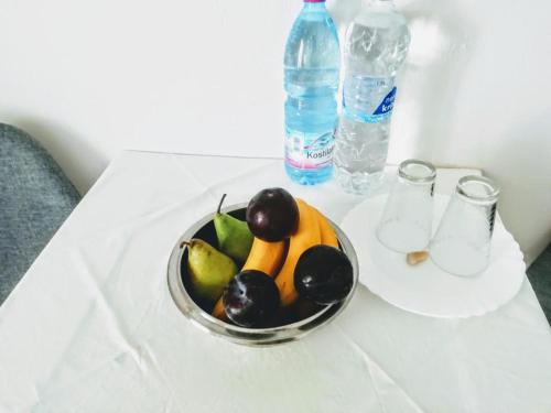 a bowl of fruit on a table with a bottle of water at Logaras Seaview Apartment in Logaras