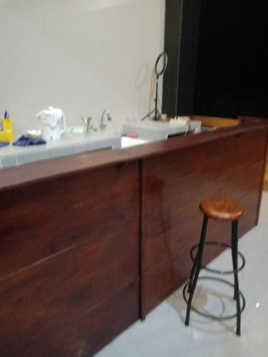 a kitchen counter with a sink and a stool at Ubud Suites Batuan in Sukawati