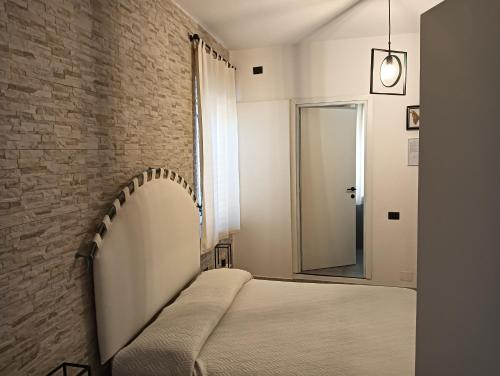 1 dormitorio con cama y pared de ladrillo en Domos Le Due Tuie, en Piscinas